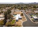 An aerial shot displays the house, pool, neighborhood, nearby street and an expansive view of the community at 6071 E Ludlow Dr, Scottsdale, AZ 85254