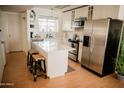 Modern white kitchen with stainless steel appliances and a spacious island at 7023 E 4Th St # 104, Scottsdale, AZ 85251