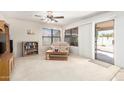 Bright living room with carpet, a ceiling fan, sofa and sliding door access at 10510 W Louise Dr, Peoria, AZ 85383