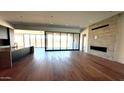 Open-concept living room featuring hardwood floors, a modern fireplace, and large sliding glass doors at 13116 E Desert Holly Dr, Scottsdale, AZ 85255