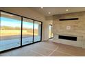 Bright living room with a fireplace and sliding glass doors that offer a view of the backyard at 13278 E Buckskin Trl, Scottsdale, AZ 85255