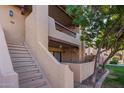 Exterior view of a building with stucco walls, a balcony, and stairs leading to upper units at 1351 N Pleasant Dr # 2030, Chandler, AZ 85225