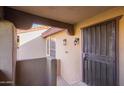 Private condo entrance with security door, tan stucco walls, and a covered ceiling at 1351 N Pleasant Dr # 2030, Chandler, AZ 85225