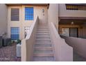 Exterior view of condo stairway with tan stucco walls and view of surrounding buildings at 1351 N Pleasant Dr # 2030, Chandler, AZ 85225