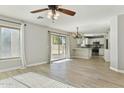 Open-concept living room with tile flooring, backyard access, and a view of the kitchen and breakfast bar at 14970 N 172Nd Dr, Surprise, AZ 85388