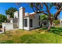 View of home showcasing a charming architectural design, verdant lawn, and mature tree providing shade at 1717 E Union Hills Dr # 1065, Phoenix, AZ 85024