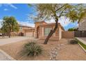 Inviting single-story home with desert landscaping, a three-car garage and tiled roof at 18415 W Port Au Prince Ln, Surprise, AZ 85388