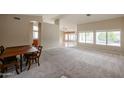 Open-concept living area with neutral carpeting, bright natural light, and seamless transitions to other living spaces at 19507 N 90Th Ln, Peoria, AZ 85382