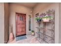 Charming front entrance featuring a wooden door and decorative flower display at 2404 W Muirfield Dr, Anthem, AZ 85086