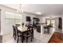 Bright dining area with a stone table, dark wood chairs, and an open flow to the kitchen and living spaces at 28916 N Selenite Ln, San Tan Valley, AZ 85143