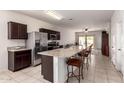 Open-concept kitchen with stainless steel appliances, a large granite island, and bar stool seating at 28916 N Selenite Ln, San Tan Valley, AZ 85143