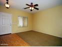 Bright living room featuring large windows and a ceiling fan, creating a comfortable and inviting atmosphere at 4253 E Colonial Dr, Chandler, AZ 85249