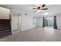 Spacious living area with tile floors, a ceiling fan, and stairs to the upper level near the sliding glass door at 5106 N 17Th Ave # 11, Phoenix, AZ 85015