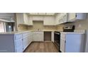 Well-lit kitchen with white cabinets, stainless steel appliances, and neutral countertops at 9445 N 94Th Pl # 201, Scottsdale, AZ 85258