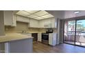 Bright kitchen featuring white cabinetry, stainless steel appliances and a sliding glass door to balcony at 9445 N 94Th Pl # 201, Scottsdale, AZ 85258