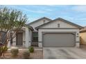 Attractive home featuring a two-car garage, neutral stucco, and easy-care desert landscaping at 9509 W Illini St, Tolleson, AZ 85353