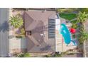 Aerial view of a property with a sparkling pool, covered patio, and lush landscaping at 9517 W Cedar Hill Cir # N, Sun City, AZ 85351