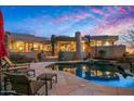 Beautiful exterior view of desert home with a pristine pool and luxurious lounge chairs at 9962 E Groundcherry Ln, Scottsdale, AZ 85262