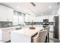 Bright kitchen with white cabinetry, a large island, stylish backsplash, and stainless steel appliances at 11215 N 37Th Ave, Phoenix, AZ 85029