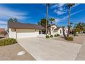 Charming single-story home featuring a two-car garage, landscaped yard, and palm trees at 13544 W Whitewood Dr, Sun City West, AZ 85375