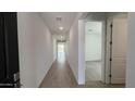 Bright hallway with tile flooring leading to carpeted bedroom and naturally lit common areas at 15765 W Cheryl Dr, Waddell, AZ 85355