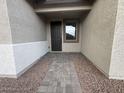 Well-lit entryway leading to the front door with decorative stone walkway at 15778 W Cheryl Dr, Waddell, AZ 85355