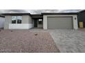 Charming single-story home featuring a brick driveway and a two-car garage at 15778 W Cheryl Dr, Waddell, AZ 85355