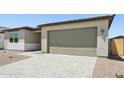 View of the home's garage with its multi-panel door, and a paver driveway, and desert landscaping at 15778 W Cheryl Dr, Waddell, AZ 85355