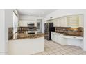 Bright kitchen featuring white cabinetry, granite countertops, stainless steel appliances, and tile floors at 15825 S 1St Ave, Phoenix, AZ 85045