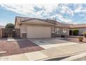 Charming single-story home with a well-manicured lawn and a neutral-toned exterior at 16043 W Saguaro Ln, Surprise, AZ 85374