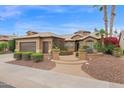 Landscaped home exterior with a two-car garage, desert landscaping, and a curved walkway to the front door at 16215 W Indianola Ave, Goodyear, AZ 85395