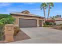 Home exterior showcasing the garage, desert landscaping, and a private mailbox with palm trees in the background at 16215 W Indianola Ave, Goodyear, AZ 85395