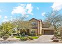 Stunning two-story home featuring a stone facade, well-manicured landscaping, and a spacious driveway leading to a garage at 17893 N 93Rd St, Scottsdale, AZ 85255
