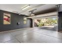 Spacious and clean garage featuring an open door to the driveway, neutral walls, and a sealed concrete floor at 17893 N 93Rd St, Scottsdale, AZ 85255