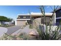 Modern home featuring desert landscaping, stone accents, and a striking curved architectural element at 1830 E Palmaire Ave, Phoenix, AZ 85020