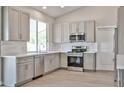 Stylish kitchen features gray cabinets, stainless appliances, and bright natural light at 19824 N 94Th Ln, Peoria, AZ 85382