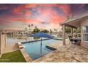 Backyard pool overlooking the peaceful lake, with an umbrella and outdoor dining area for relaxation and entertainment at 3121 N Meadow Dr, Avondale, AZ 85392