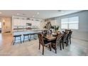 Bright, open kitchen/dining area with white cabinets, granite counters, and a large dining table at 3353 W Shanley Ave, Apache Junction, AZ 85120