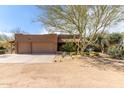 Home exterior showcasing a three-car garage, desert landscaping, and a well-maintained facade at 38408 N 23Rd Dr, Phoenix, AZ 85086