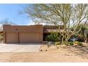 Home exterior showcasing a three-car garage, desert landscaping, and a well-maintained facade at 38408 N 23Rd Dr, Phoenix, AZ 85086