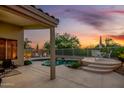 Inviting pool area with water feature and desert landscaping at dusk at 4252 E Desert Sky Ct, Cave Creek, AZ 85331