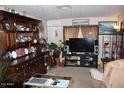 View of a cozy living room featuring a large TV, a comfortable chair, and a large hutch at 7807 E Main St # F-30, Mesa, AZ 85207