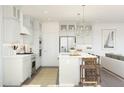 A well-lit kitchen featuring stainless steel appliances, a center island with seating, and contemporary light fixtures at 7970 W Griswold Rd, Peoria, AZ 85345