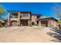Stunning multi-level home featuring stone accents, multiple garages, and a spacious brick driveway at 9290 E Thompson Peak Pkwy # 470, Scottsdale, AZ 85255