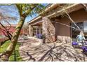 An outdoor covered patio featuring stone pillars, an outdoor dining set, and view of lush landscaping at 10883 E La Junta Rd, Scottsdale, AZ 85255