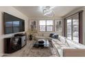 Cozy living room with a plush white sectional sofa, media center and a large TV at 13568 N 144Th Dr, Surprise, AZ 85379