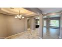 Formal dining room with statement light fixture, marble floors, and access to kitchen and living areas at 1544 N Rico Cir, Mesa, AZ 85213