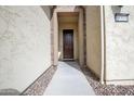 Close-up of a charming front door, framed by a stone archway and accented with decorative gravel at 16868 W Earll Dr, Goodyear, AZ 85395