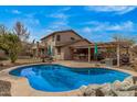 Expansive backyard showcasing a sparkling pool, covered patio, and outdoor kitchen, perfect for entertaining and relaxation at 1917 S Rock Ct, Gilbert, AZ 85295