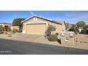 A neat single-story house features a two-car garage and desert landscaping at 2101 S Meridian Rd # 354, Apache Junction, AZ 85120